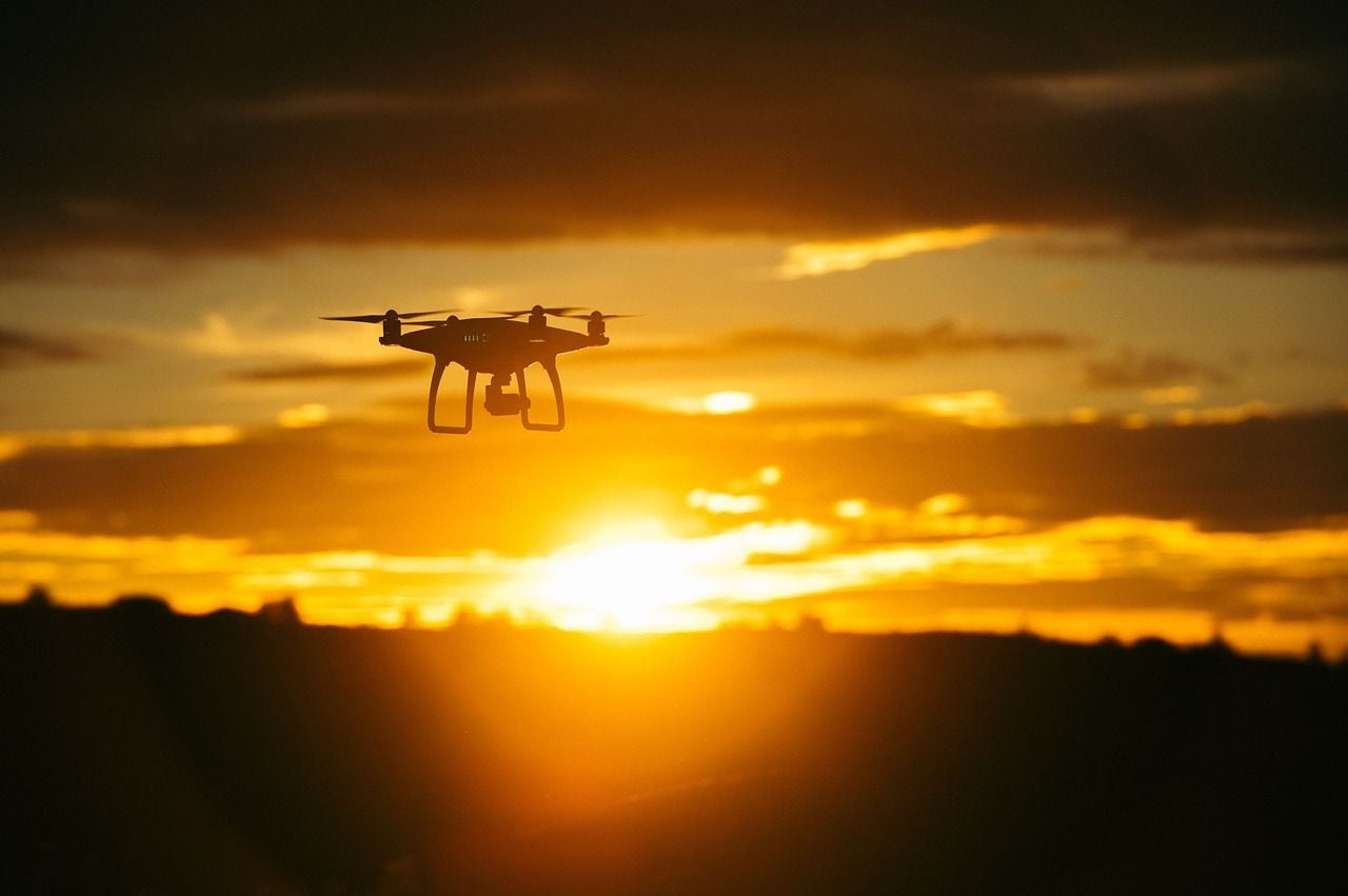 Drohne fliegt bei Sonnenuntergang