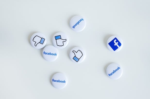 Weisse button pins mit blauer Schrift von facebook 