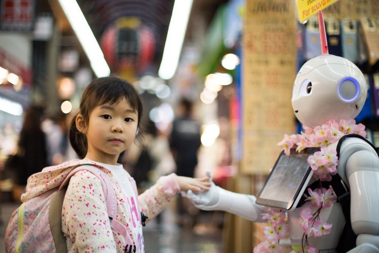Kind Hand in Hand mit Roboterassistenten
