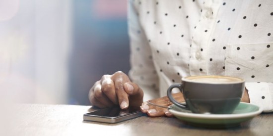 hands with smartphone and cup of coffee