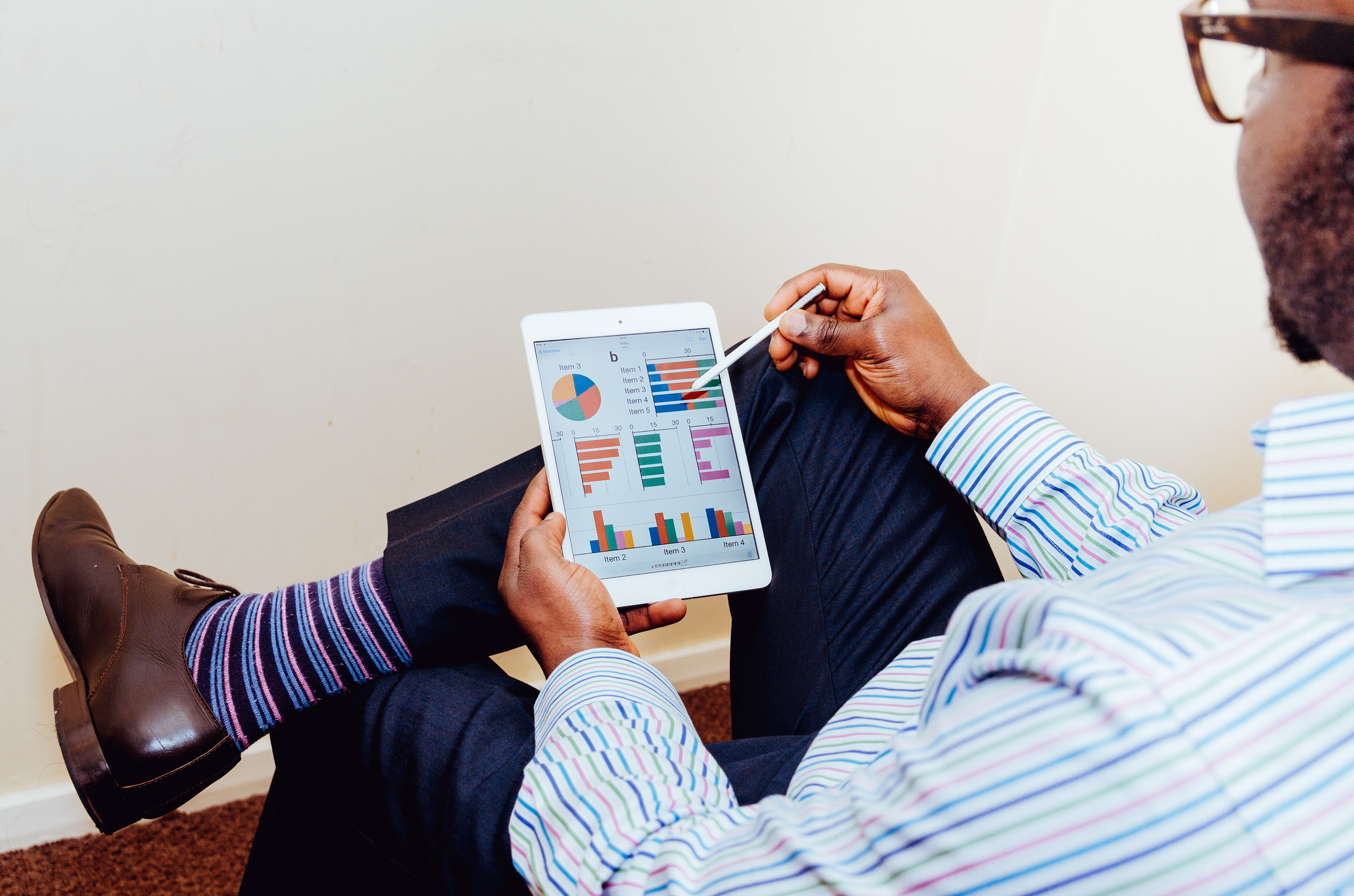 man sitting and holding an ipad