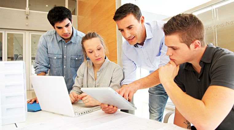 four people talking and showing on ipad and notebook