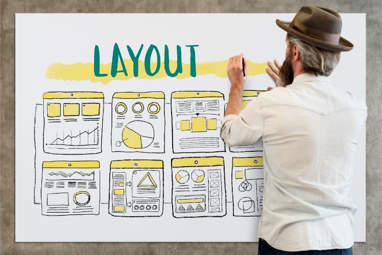 man standing in front of a whiteboard creating the layout of a website