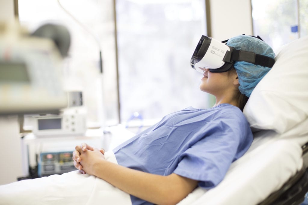 jeune femme porte un casque de realite virtuelle dans un lit hopital
