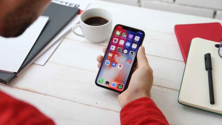 jeune homme tient un iphone dans sa main jeune homme tient un iphone dans sa main