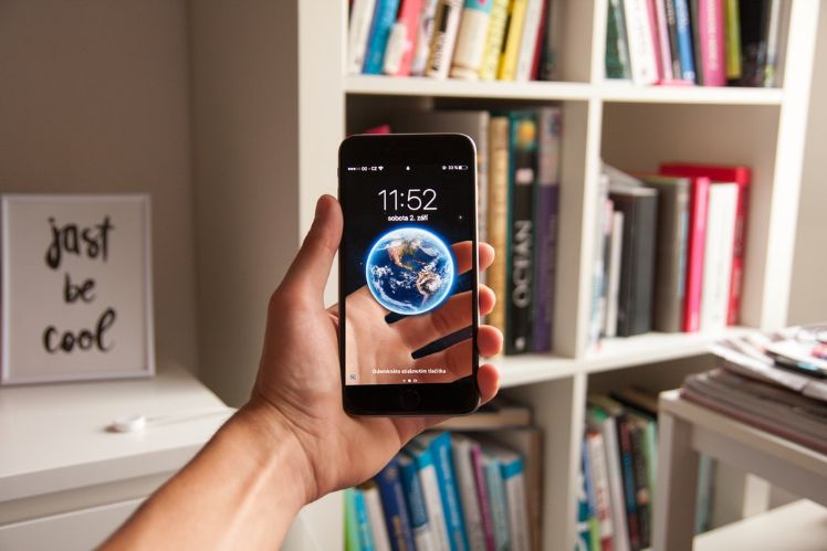 Smartphone con libreria sullo sfondo