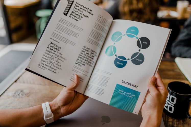 manos sosteniendo un libro sobre estrategias de negocios manos sosteniendo un libro sobre estrategias de negocios